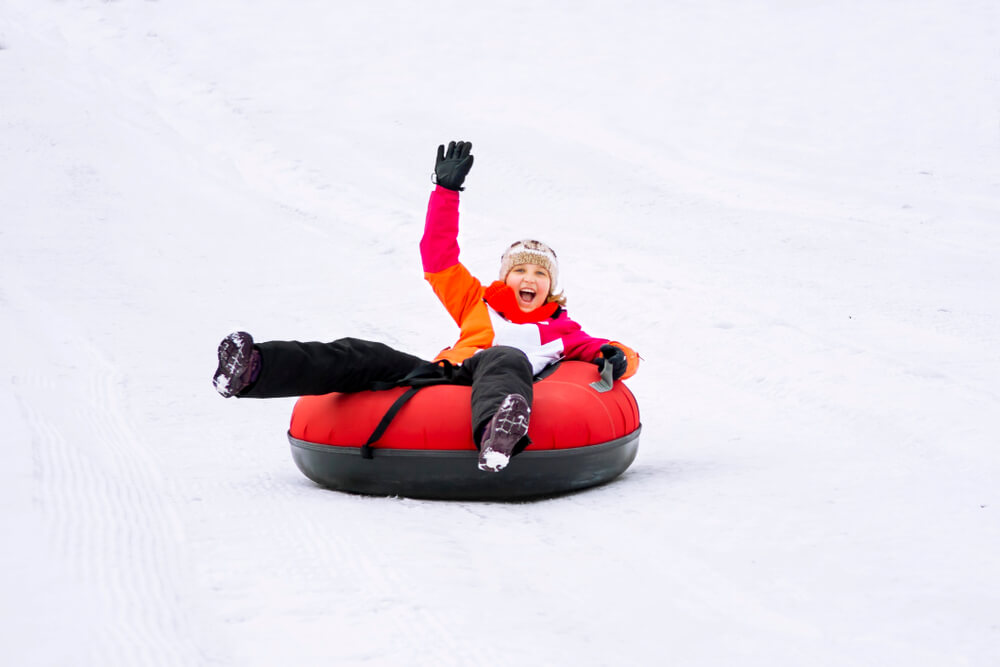 A person snow tubing on a winter vacation in Gatlinburg.